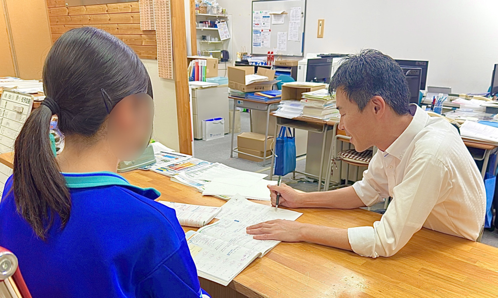生徒のノートを見ながら説明する講師の様子